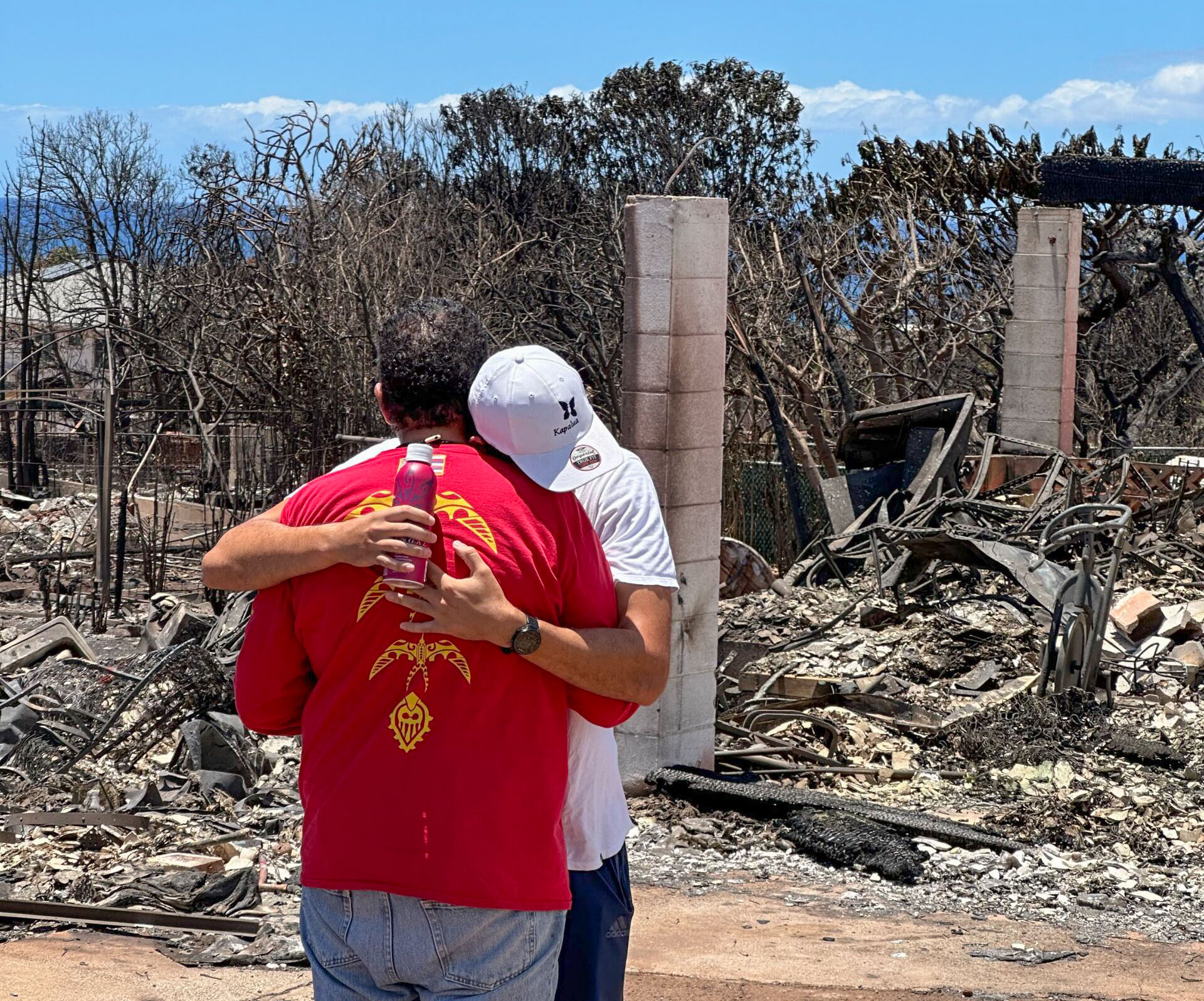 Family members embrace outside their burned-down home in Wahikuli. Photo courtesy: Nate Kahaiali'i