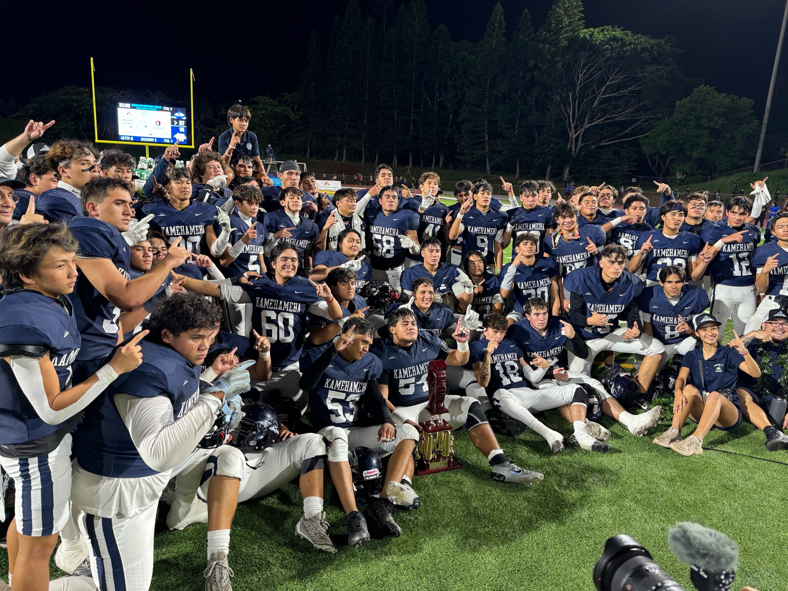 The Kamehameha Schools Maui Division II state football champions pose with the Koa warrior head state championship trophy Saturday night in Mililani. HJI / ROB COLLIAS photo