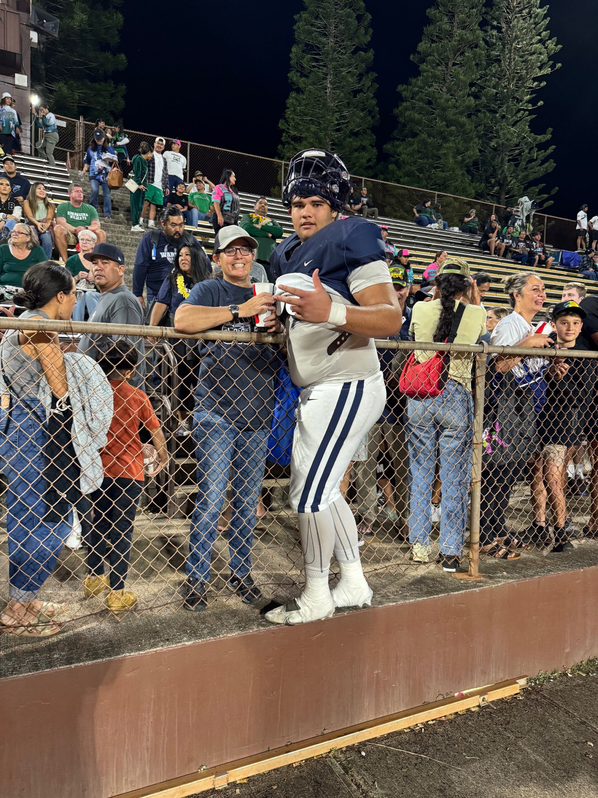 Kamehameha Schools Maui offensive lineman Pa'u Spencer greets his mother Lisa Spencer in the crowd at John Kauinana Stadium in Mililani on Saturday after the Warriors beat Kaiser 37-14 for the Division II state championship. HJO / ROB COLLIAS photo