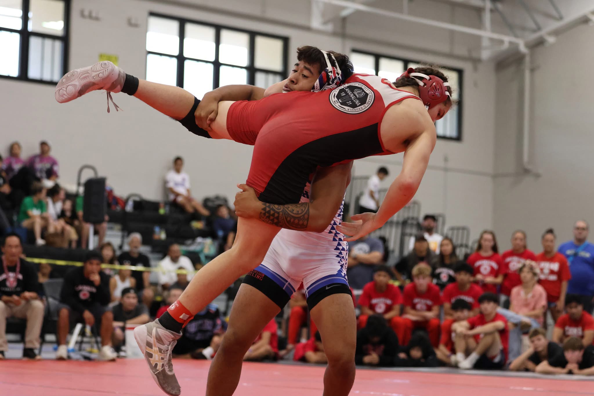 Mikah Labuanan of Kamehameha Schools Maui, lifts Lahainaluna's Anakin Hayes in their 150-pound final at the Garner Ivey Maui Invitational Tournament in Kihei on Saturday. Labuanan won the match by pin in the second period. JASON HAYASE photo