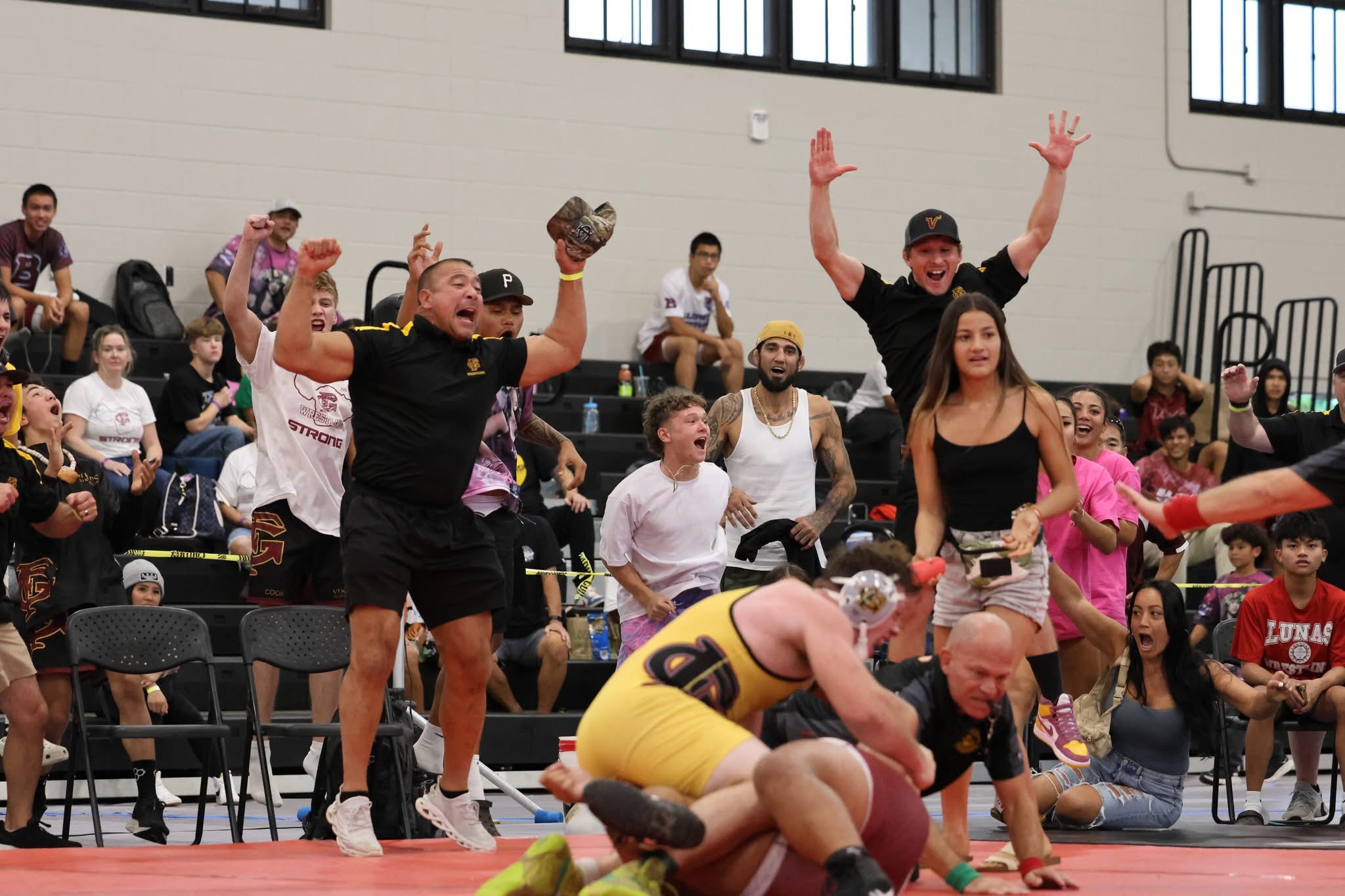 Guy Takahashi, the head coach for Forest Grove (Ore.) High School, celebrates (left, hat in hand) as Forest Grove heavyweight Carter Bennett finished a pin over Pita Takafua of Baldwin in the final match of the Garner Ivey Maui Invitational Tournament at the South Maui Community Gymnasium. JASON HAYASE photo