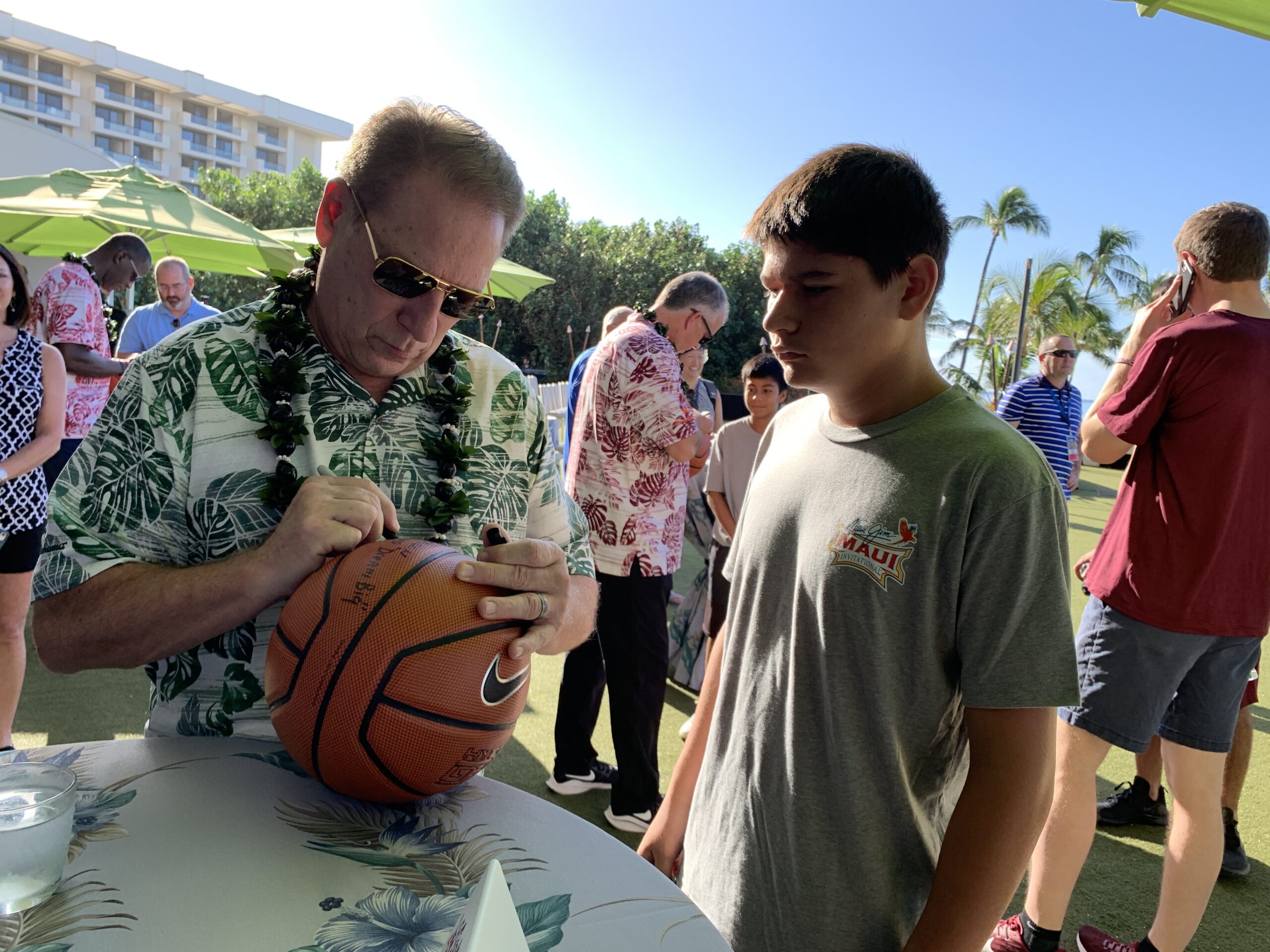 Michigan State University basketball coach Tom Izzo signs a basketball for a young local fan in 2019 following the coaches' news conference at the Hyatt Regency Maui. HJI / ROB COLLIAS photo