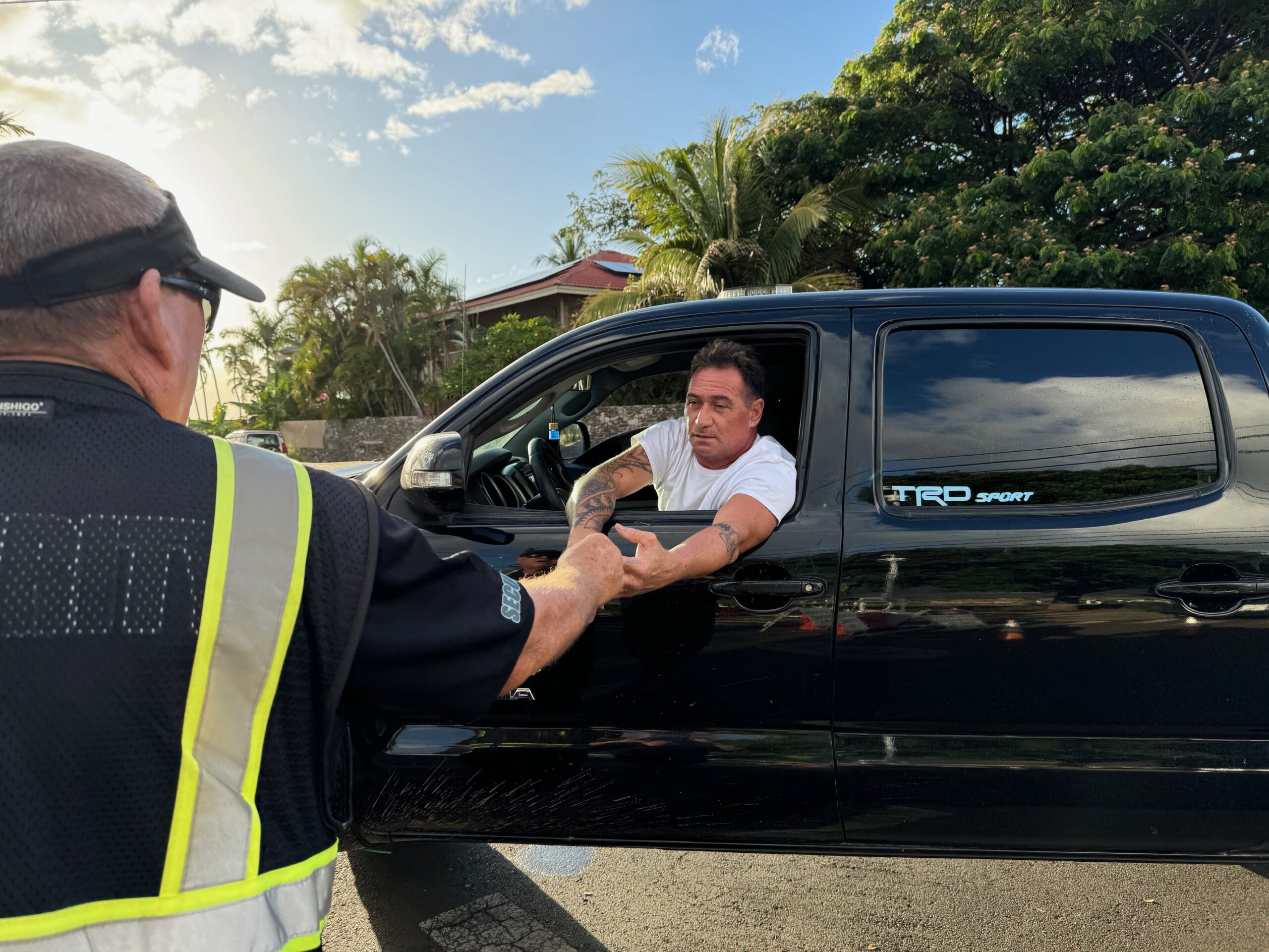 Roland Tanner, the main organizer of the Wahikuli neighborhood watch program, greets Aegaeon security guard Tim Putnam on Wednesday. Tanner does two rounds of patroling the neighborhood every day. HJI / ROB COLLIAS photo