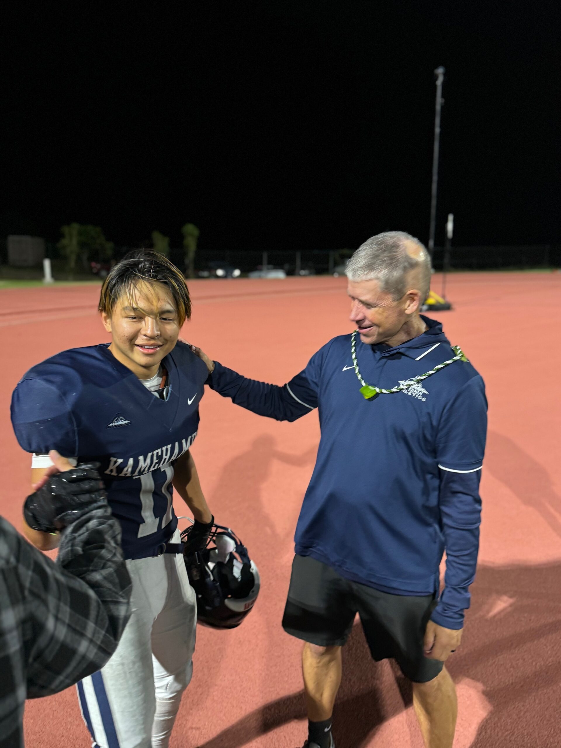 Kamehameha Schools Maui kickoff returner Tevyn Apo receives congratulations from special teams coach Kevin O'Brien after the Warriors' 60-26 win over Roosevelt on Saturday in Pukalani. Apo returned two kickoffs for touchdowns in the game. HJI / ROB COLLIAS photo